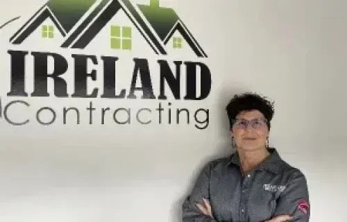 Lora Chiappialle, administrative staff at Ireland Contracting, standing in front of the company logo.